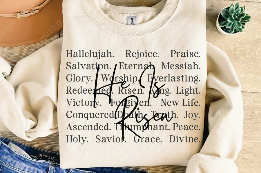 Cross-shaped Christian words and He Is Risen typography on a cream shirt